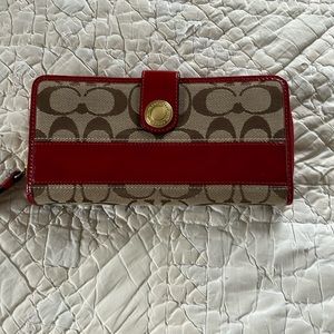 Coach signature zip wallet with red patent leather trim.